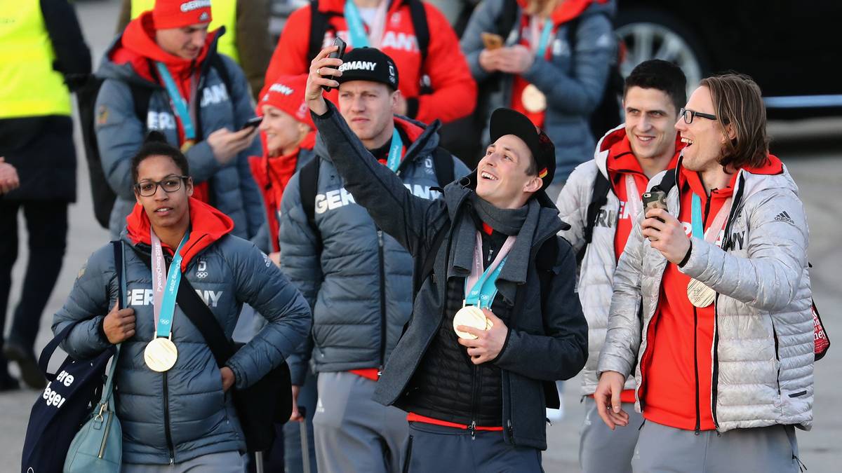 Vorher werden aber noch jede Menge Selfies zur Erinnerung geschossen. Kombinierer Eric Frenzel (Mitte) knipst Fahnenträger-Kollegen Christian Ehrhoff (rechts) ab