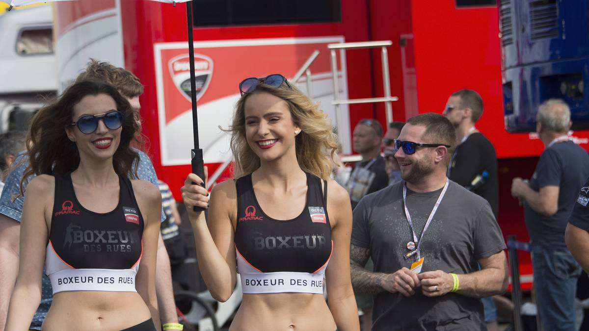 Aus Kleidungssicht sind die Grid Girls von der MotoGP deutlich regenfester. Allerdings: der Regenschirm? Auf der Insel? Nicht ihr Ernst...