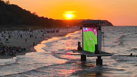 Überall im Land verfolgen viele Menschen die EM-Spiele beim Public Viewing. Einer der schönsten Orte, um gemeinsam Fußball zu schauen, bietet sich den Fans am Ostsee-Strand in Heringsdorf. Das nutzen auch einige Bundesliga-Legenden.