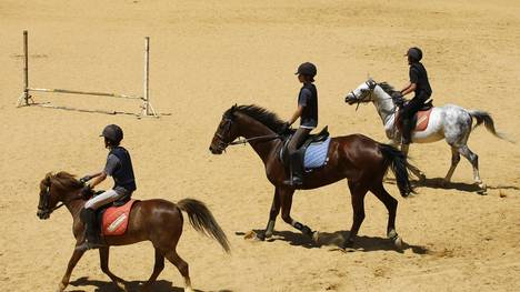 Lebanese youths ride horses at a horse r
