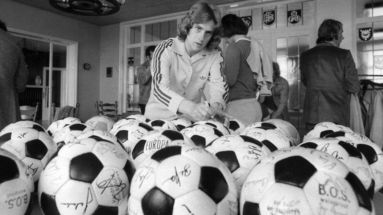 Helmut Kremers signiert Bälle in der Sportschule Malente