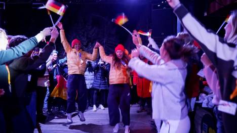 Die Frauen gewinnen im Zweierbob souverän Olympia-Gold und -Silber. Diesen Erfolg feiern sie im Deutschen Haus in Cortina. 
