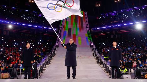 IOC-Präsident Thomas Bach schwenkt die Olympische Fahne