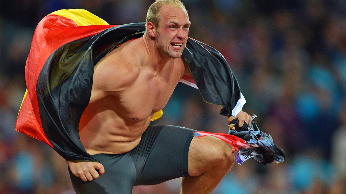 Robert Harting nach seinem Olympiasieg 2012: Das Trikot zerrissen, die Deutschlandflagge über den Schultern setzt er zum Hürdenlauf an