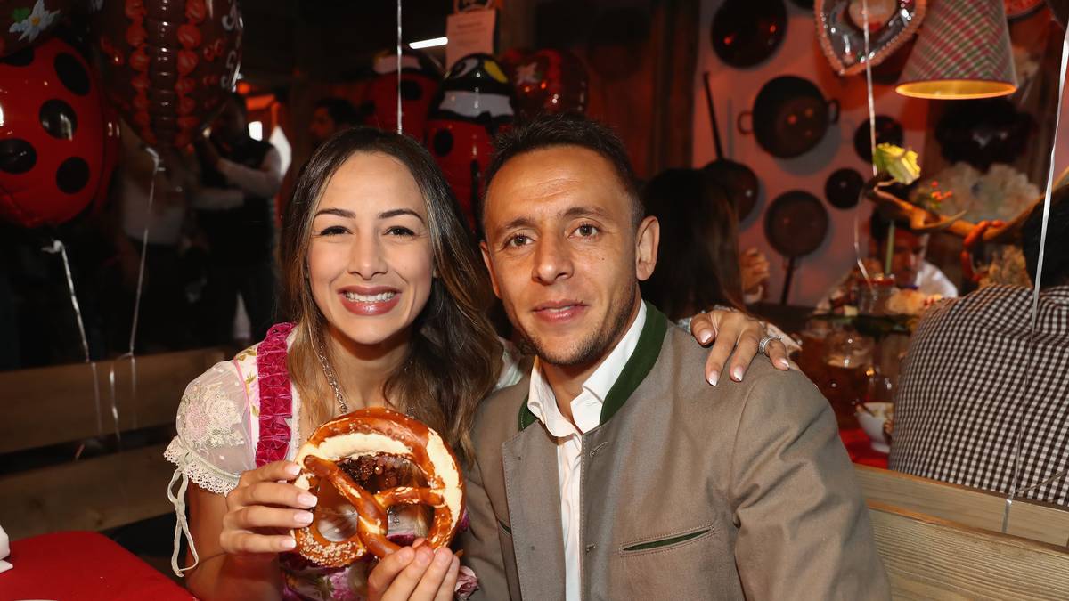 Rafinha und Freundin Carolina posieren stolz mit einer Breze