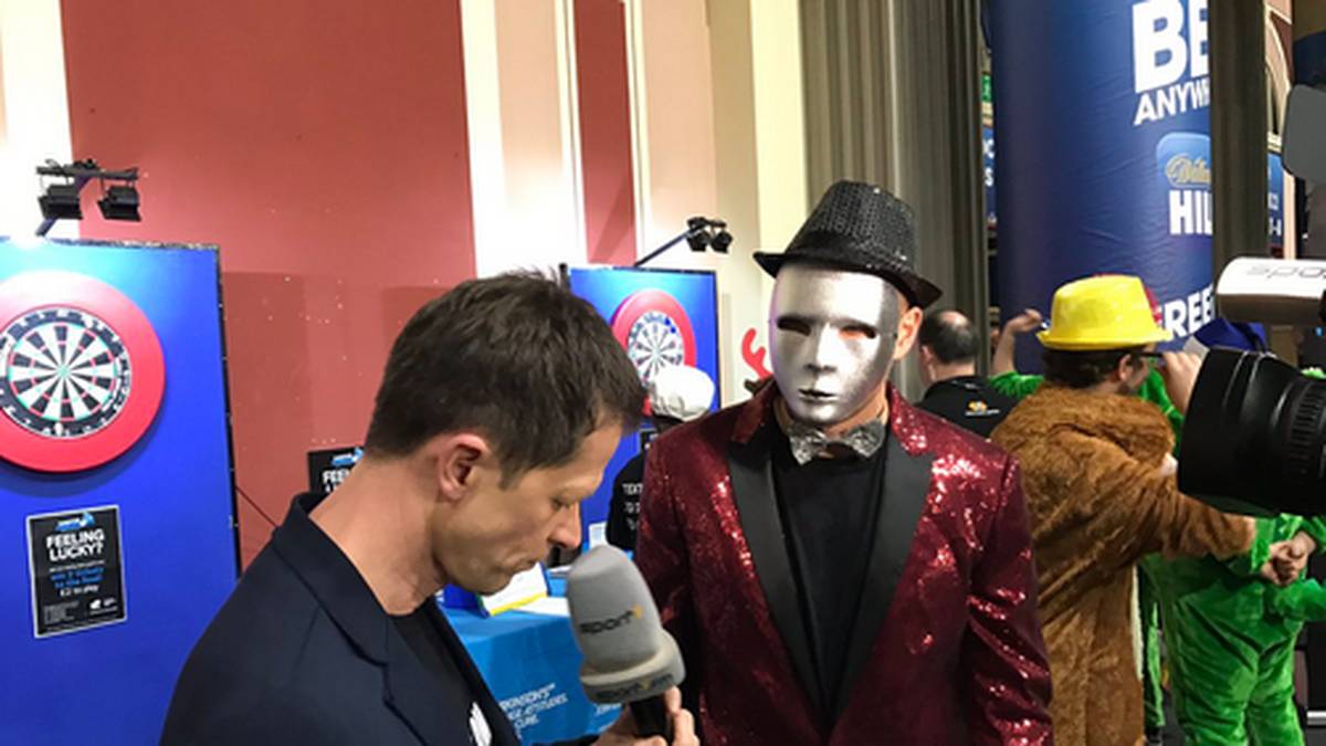 Dass Fußballer auf Darts abfahren, ist bekannt. Doch welcher Bundesliga-Star steckt hinter der silbernen Maske?
