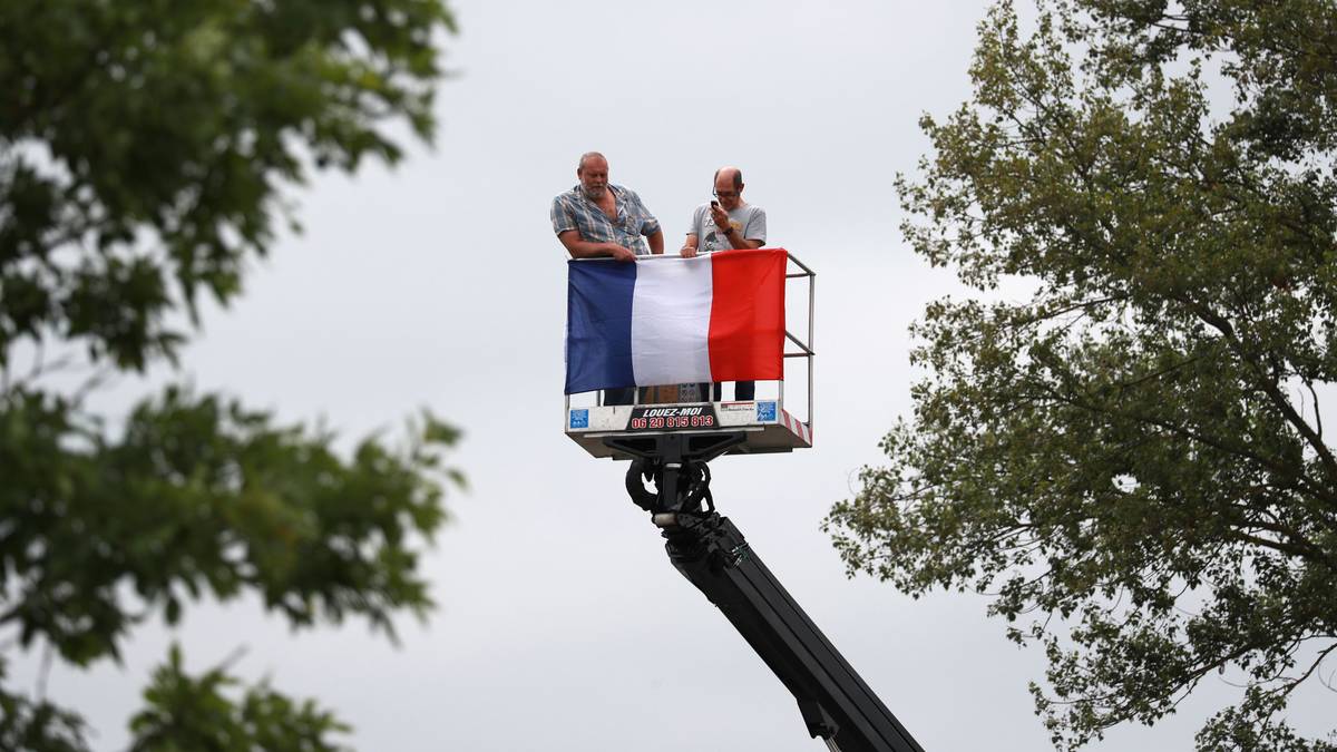 Die Fans bringen sich auf dem 184 Kilometer langen Teilstück in Position. Diese beiden Radsportanhänger zeigen in luftiger Höhe, für wen sie die Daumen drücken