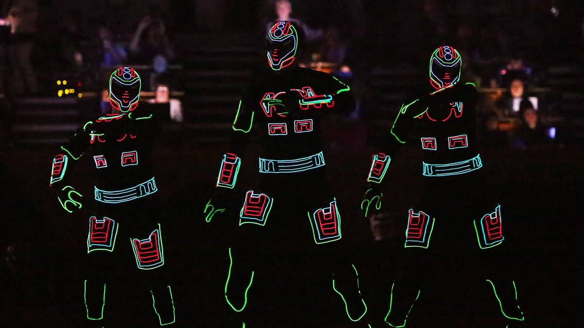 Diese Tänzer wählen mal ein ganz leuchtendes Outfit - und erinnern ein wenig an eine Mischung aus Daft Punk und Kraftwerk. In der abgedunkelten Halle sorgen diese Tänzer für Begeisterung