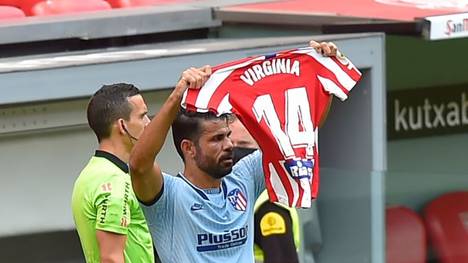 Diego Costa hält das Trikot einer Atlético-Spielerin hoch