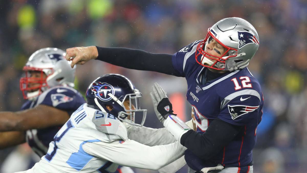 Tom Brady of the New England Patriots passes under pressure from Harold Landry of the Tennessee Titans in the second half of the AFC Wild Card Playoff game at Gillette Stadium