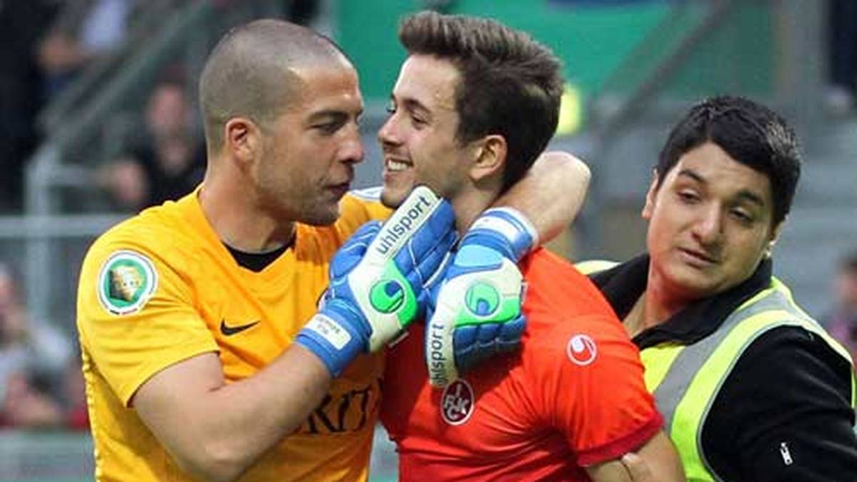 Der Schlussmann der Gastgeber nimmt sich den Flitzer mit FCK-Emblem auf dem Shirt zur Brust und geigt ihm seine Meinung