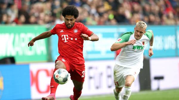 AUGSBURG, GERMANY - OCTOBER 19: Serge Gnabry of FC Bayern Munich runs with the ball past Philipp Max of FC Augsburg during the Bundesliga match between FC Augsburg and FC Bayern Muenchen at WWK-Arena on October 19, 2019 in Augsburg, Germany. (Photo by Alexander Hassenstein/Bongarts/Getty Images)
