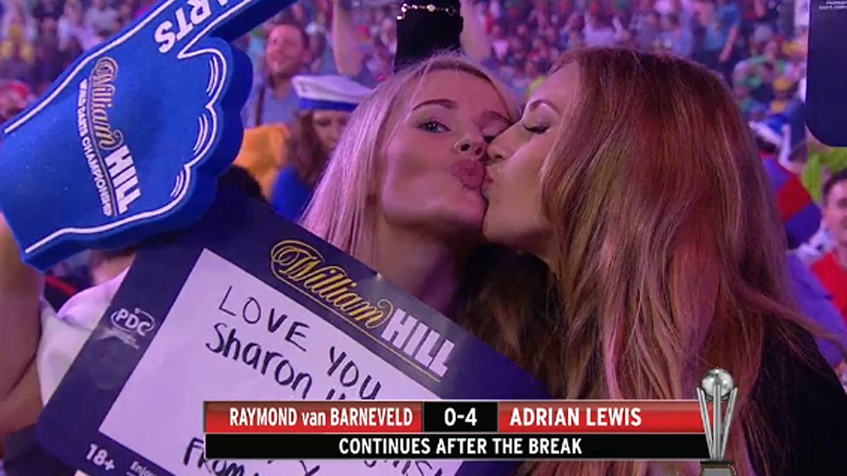 Zwei weibliche Dart-Fans geben sich ein Küsschen vor laufender TV-Kamera