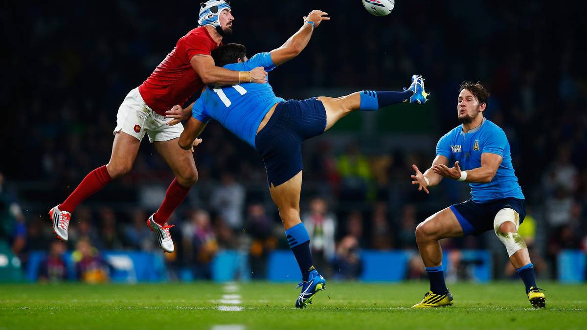 Italiens Giovanbattista Venditti (r) hat sich schon positioniert und wartet auf das Ei, während sein Teamkollege Andrea Masi noch mit den Franzosen Alexandre Dumoulin zu tun hat