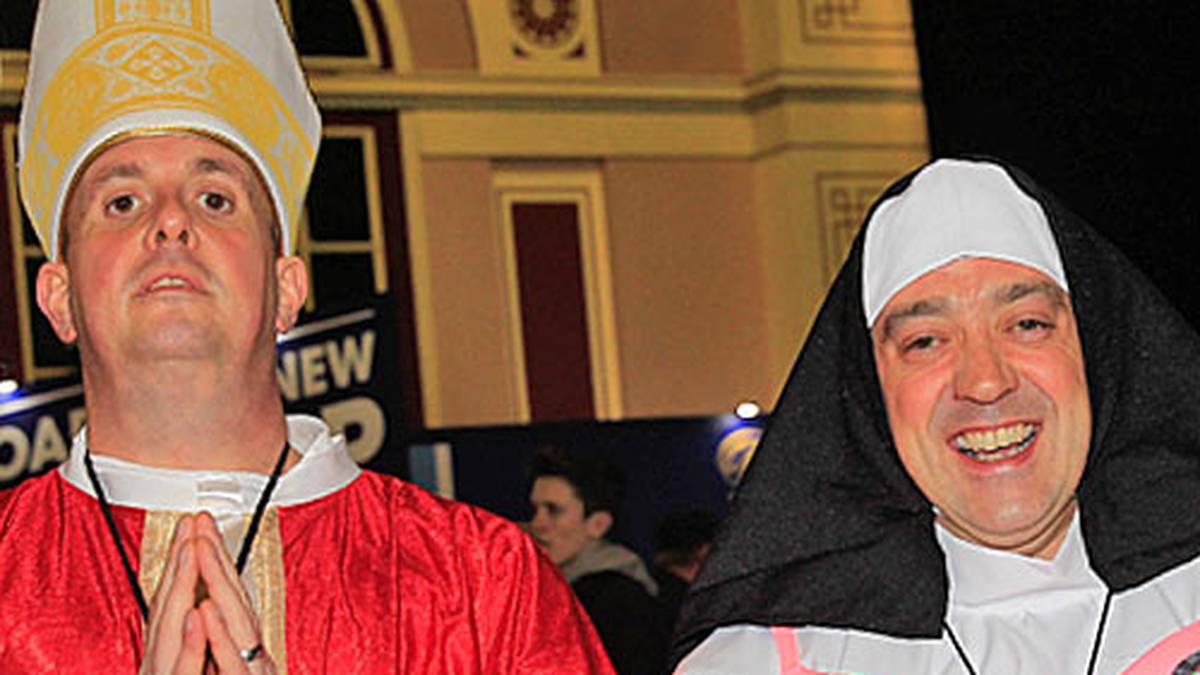 Ist das vielleicht das Finale? Darts-Papst van Gerwen (l.) oder Nonne Phil Taylor (r., mit einem bemerkenswerten Darts-BH). Eins ist klar ? der Papst wird gestürzt (Copyright: twitter.com/pdc)