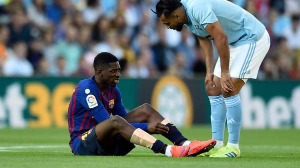 Celta Vigo's Moroccan midfielder Sofiane Boufal (R) checks on Barcelona's French forward Ousmane Dembele after resulting injured during the Spanish league football match between RC Celta de Vigo and FC Barcelona at the Balaidos stadium in Vigo on May 4, 2019. (Photo by Miguel RIOPA / AFP) / The erroneous byline appearing in the metadata of this photo by MIGUEL RIOPA has been modified in AFP systems in the following manner: [Miguel Riopa] instead of [Oscar Pozo]. Please immediately remove the erroneous mention[s] from all your online services and delete it (them) from your servers. If you have been authorized by AFP to distribute it (them) to third parties, please ensure that the same actions are carried out by them. Failure to promptly comply with these instructions will entail liability on your part for any continued or post notification usage. Therefore we thank you very much for all your attention and prompt action. We are sorry for the inconvenience this notification may cause and remain at your disposal for any further information you may require.        (Photo credit should read MIGUEL RIOPA/AFP via Getty Images)