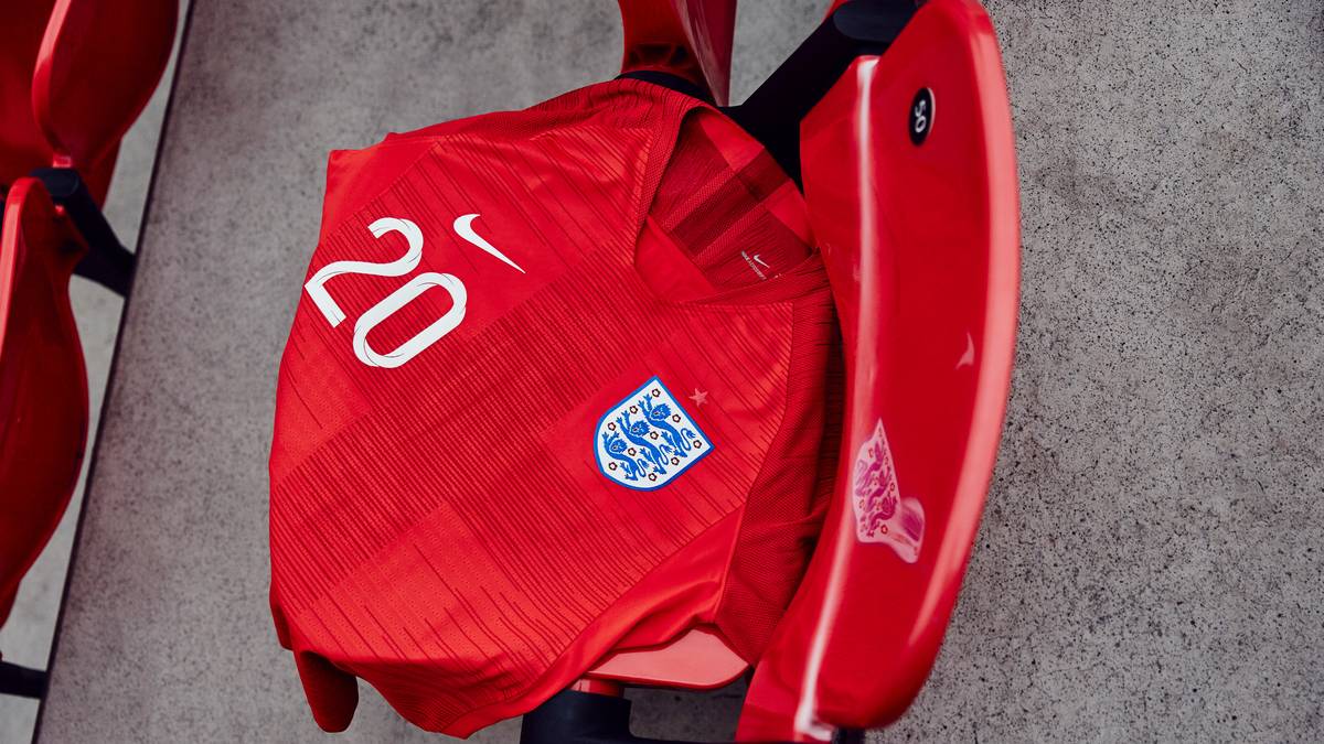 Beim Ausweichtrikot setzen die Engländer auf die Signalfarbe Rot. Auf der Brust schimmert das Georgskreuz durch, das auch auf der englischen Flagge zu finden ist