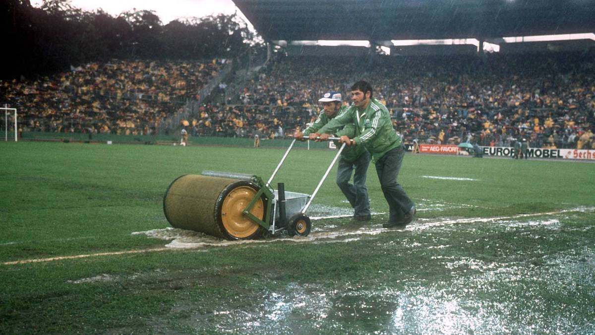 Nach einem Wolkenbruch steht das Spielfeld unter Wasser, der enge Zeitplan des Turniers lässt aber keine Verschiebung zu. Mit Wasserwalzen sollen die gröbsten Wassermassen beseitigt werden
