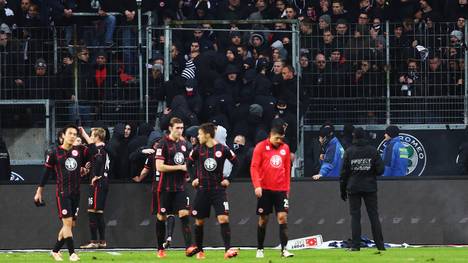 Die Spieler von Eintracht Frankfurt versuchen ihre Fans zu beruhigen