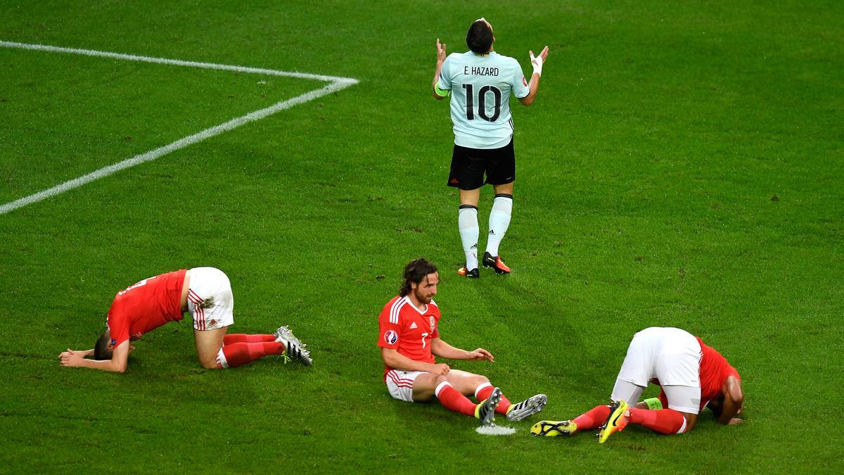 Die Briten tun sich schwer. Eine Chance von Hazard (oben) bringt drei Waliser auf den Boden. Zwei haben sich offensichtlich wehgetan