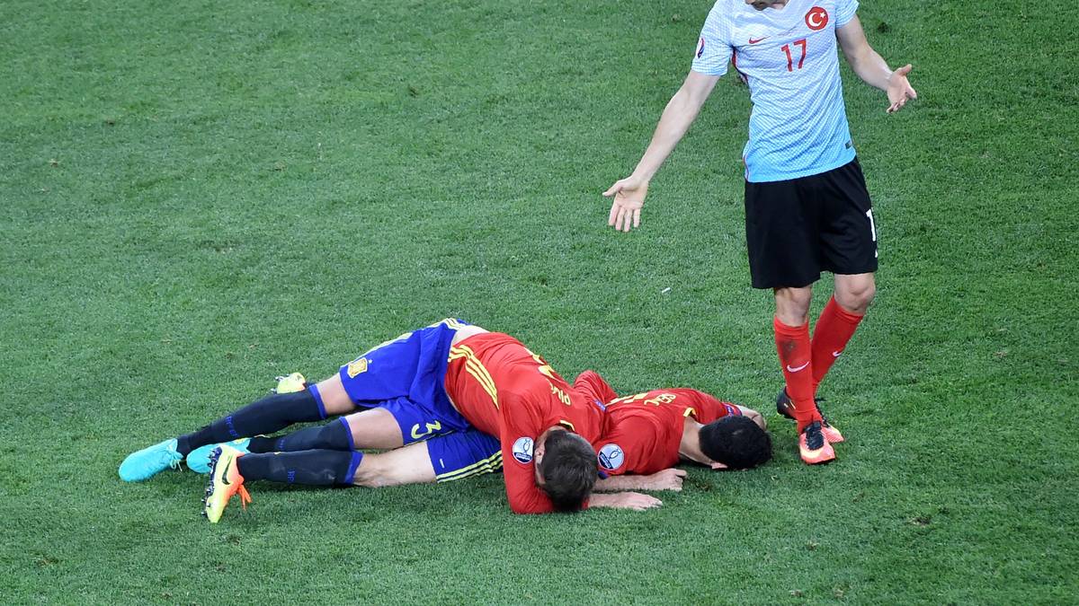 Ich hab doch gar nichts gemacht. Burak Yilmaz (r) scheint Spaniens Gerard Pique und Sergio Busquets auf dem ersten Blick ausgeknockt zu haben