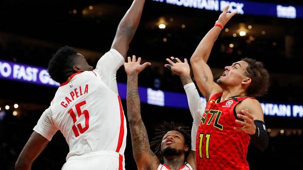 ATLANTA, GEORGIA - JANUARY 08:  Trae Young #11 of the Atlanta Hawks attempts a shot against Ben McLemore #16 and Clint Capela #15 of the Houston Rockets in the second half at State Farm Arena on January 08, 2020 in Atlanta, Georgia.  NOTE TO USER: User expressly acknowledges and agrees that, by downloading and/or using this photograph, user is consenting to the terms and conditions of the Getty Images License Agreement.  (Photo by Kevin C. Cox/Getty Images)