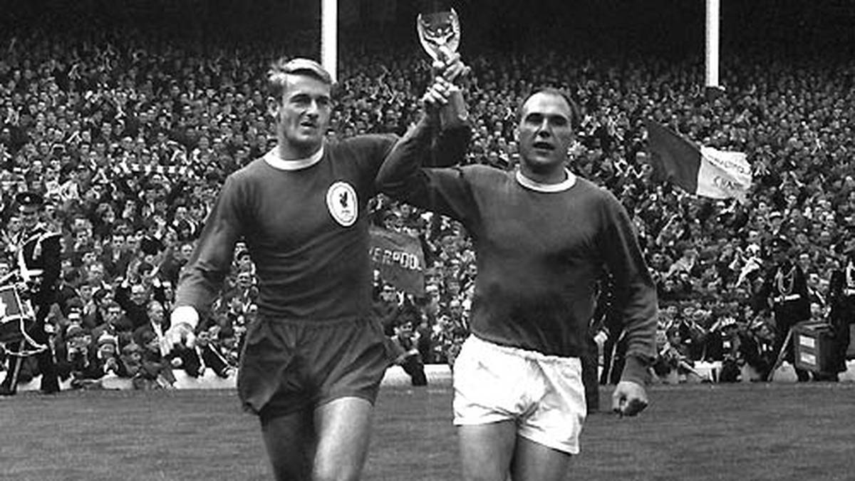 FC LIVERPOOL GEGEN FC EVERTON: In England elektrisiert neben dem Manchester-Derby seit Jahrzehnten das Merseyside-Derby zwischen den Lokalrivalen FC Liverpool und FC Everton. Zwischen 1979 und 1989 machen beide Vereine den Meistertitel fast ausschließlich unter sich aus, doch auch schon zuvor ist die Rivalität groß. Auch deshalb präsentieren die Weltmeister Roger Hunt (Liverpool, l.) und Evertons Ray Wilson den Fans 1966 gemeinsam den errungenen WM-Pokal