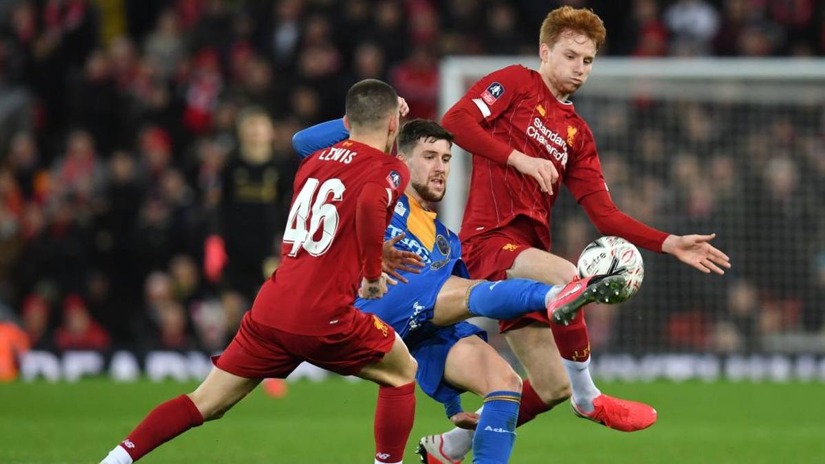 Shrewsbury Town's English striker Callum Lang (C) vies with Liverpool's English defender Adam Lewis (L) and Liverpool's Dutch defender Sepp van den Berg (R) during the English FA Cup fourth round reply football match between Liverpool and Shrewsbury Town at Anfield in Liverpool, north west England on February 4, 2020. (Photo by Paul ELLIS / AFP) / RESTRICTED TO EDITORIAL USE. No use with unauthorized audio, video, data, fixture lists, club/league logos or 'live' services. Online in-match use limited to 120 images. An additional 40 images may be used in extra time. No video emulation. Social media in-match use limited to 120 images. An additional 40 images may be used in extra time. No use in betting publications, games or single club/league/player publications. /  (Photo by PAUL ELLIS/AFP via Getty Images)