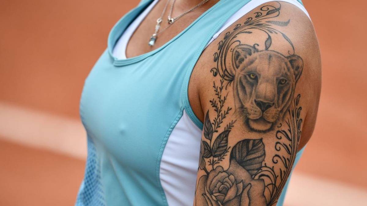 Auf einem volltätowierten Arm sticht dieser Löwe hervor