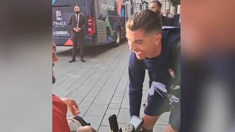 Als Cristiano Ronaldo einem Fan bei seiner Ankunft in München ein Autogramm schreibt, wird der portugiesische Superstar von dessen Rollstuhl gerammt. Eine andere Perspektive zeigt nun, wie der kleine Unfall, der zum viralen Hit wurde, wirklich zustande kam.