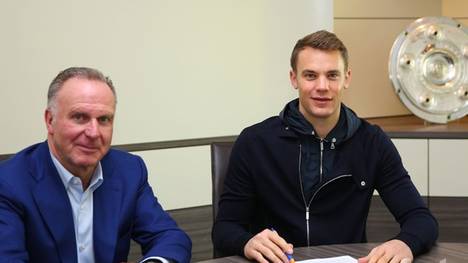 Manuel Neuer (M.) bei der Unterzeichnung des neuen Vertrages