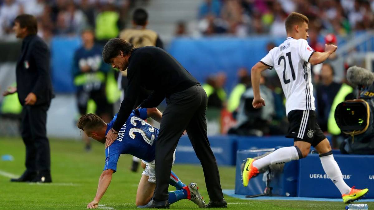 Auf dem Rasen geht es gleich nach dem Anpfiff zur Sache. Bundestrainer Joachim Löw muss sich vor Emanuele Giaccherini in Sicherheit bringen, nachdem der Offensivspieler im Zweikampf von Joshua Kimmich abgedrängt wurde