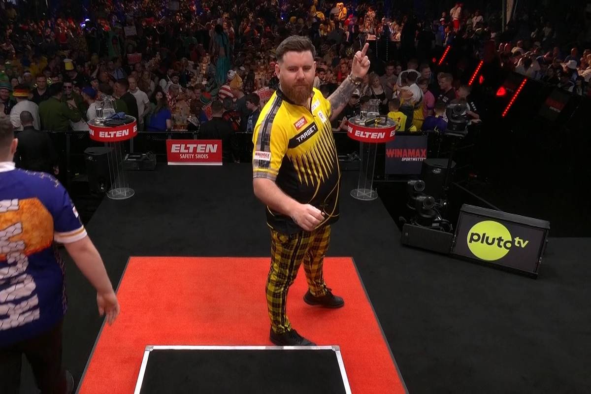 Scott Williams zeigt dem Publikum beim German Darts Grand Prix in München beim Einwerfen den Stinkefinger. Eine Geste, die Konsequenzen für ihn haben könnte.
