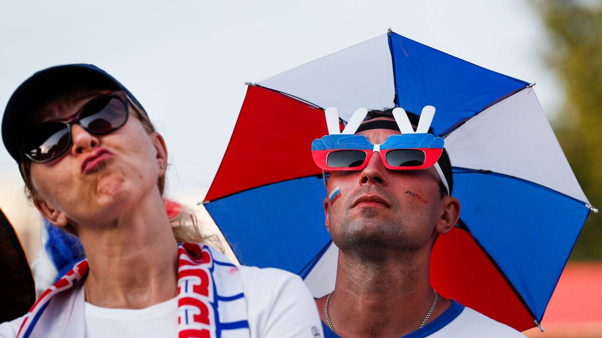 Lustig ist die Sonnenbrille mit Fernsehantenne und Russland-Sonnenschirm-Hut, zufrieden wirken die Russland-Fans aber nicht