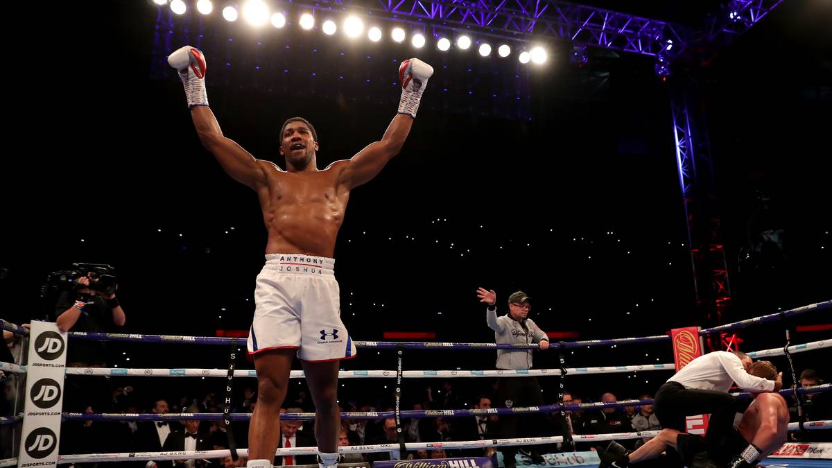 Während sich Joshua bereits als Sieger feiern lässt, kümmert sich der Ringrichter um den am Boden liegenden Russen 