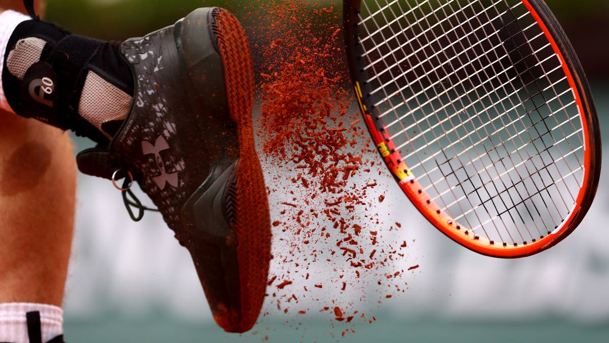 Andy Murray befreit sich von dem roten Sand, den er während seiner Partie gegen Aufschlagriese John Isner aufgesammelt hat