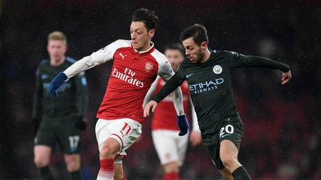 Mesut Özil (l.) vom FC Arsenal trifft zum Saisonauftakt der Premier League auf Bernardo Silva und Manchester City