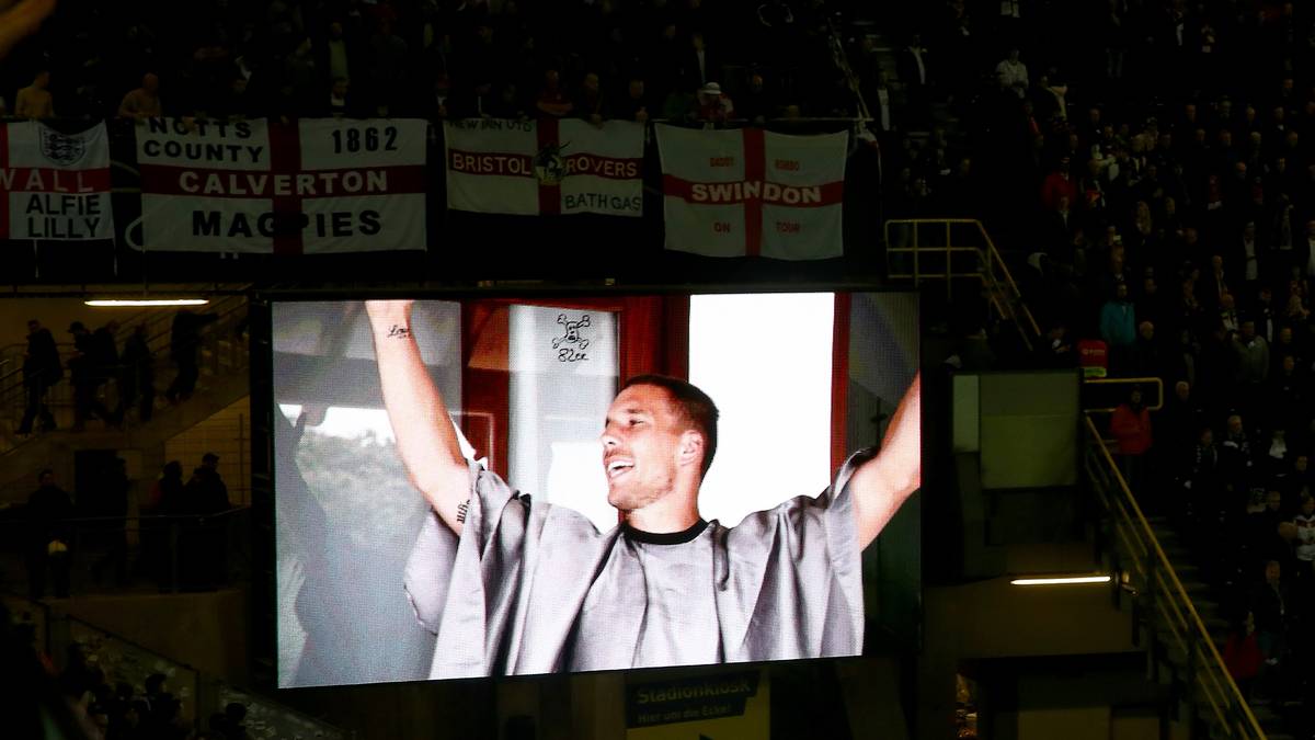 Auf der Viideowand werden Szenen aus Podolskis Karriere in der Nationalmannschaft gezeigt