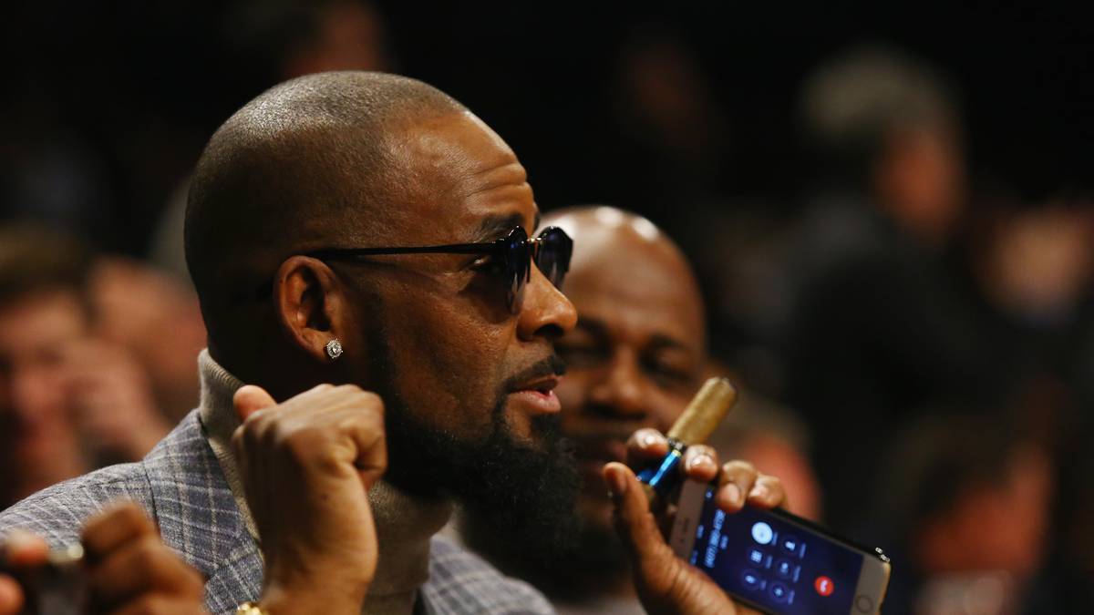 Mit Handy und Zigarre in der Hand scheint der Sänger während des Spiels sichtlich Spaß zu haben