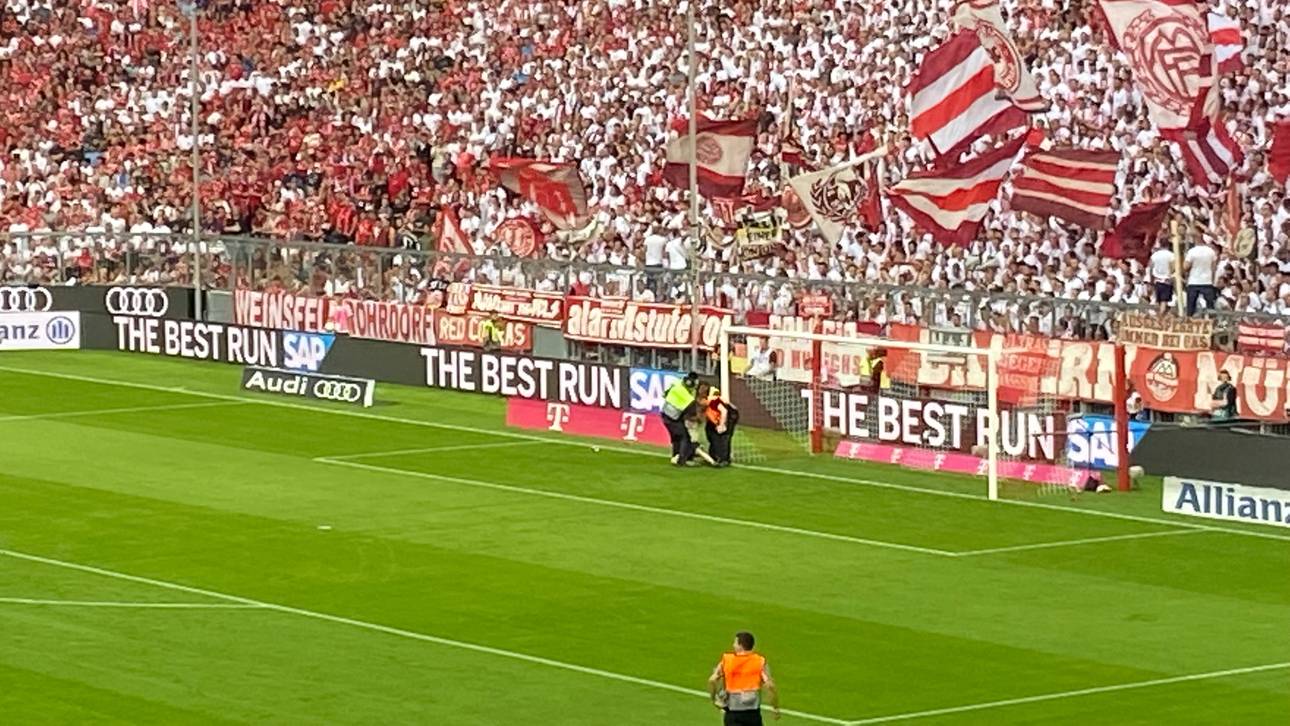 Ein Aktivist versucht sich am Bayern-Tor festzubinden