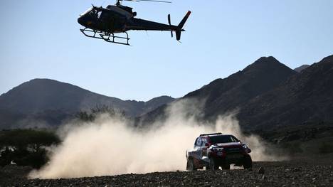 TOPSHOT - A helicopter flies as Toyota's driver Fernando Alonso of Spain and co-driver Marc Coma of Spain compete during the Stage 2 of the Dakar 2020 between Al Wajh and Neom, Saudi Arabia, on January 6, 2020. (Photo by FRANCK FIFE / AFP) (Photo by FRANCK FIFE/AFP via Getty Images)