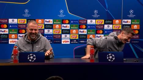 Barcelonas Trainer Hansi Flick setzt am Ende der Pressekonferenz zu einer Lobeshymne auf Robert Lewandowski an. Der Angreifer deutet scherzhaft und verlegen an, den Raum zu verlassen. 