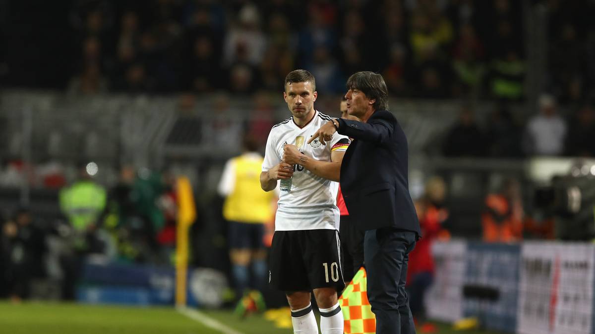 Auch wenn es sein letztes Spiel ist - soviel Zeit muss ein: Bundestrainer Joachim Löw gibt Podolski an der Seitenlinie Instruktionen