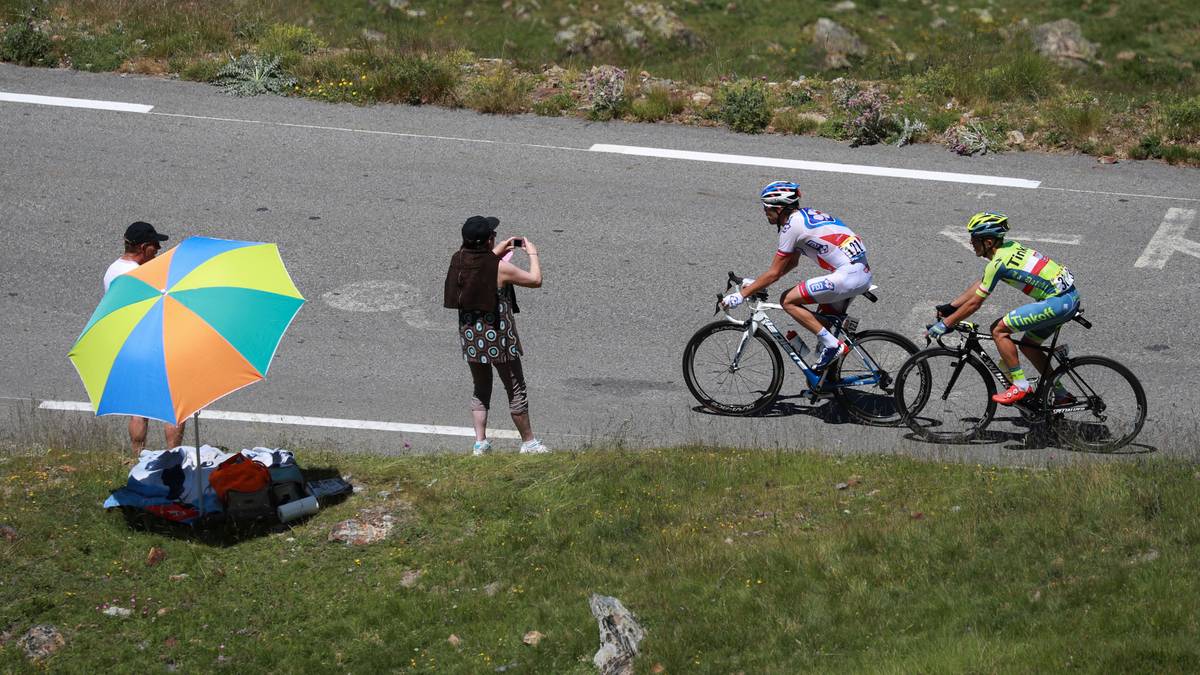 Pinot und Majka erklimmen den ersten Berg der höchsten Kategorie im Alleingang. Die Zuschauer müssen sich mit Regenschirmen zum Glück nur vor der Sonne schützen