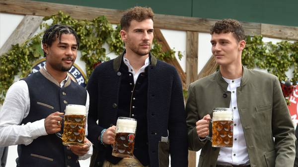 (L-R) Bayern Munich's German midfielder Serge Gnabry, Bayern Munich's German midfielder Leon Goretzka and Bayern Munich's French defender Benjamin Pavard wear traditional Bavarian Lederhosen (leather trousers) dresses as they pose during their football club's annual visit at the Oktoberfest beer festival in Munich, southern Germany, on October 6, 2019. (Photo by Christof STACHE / AFP) (Photo by CHRISTOF STACHE/AFP via Getty Images)