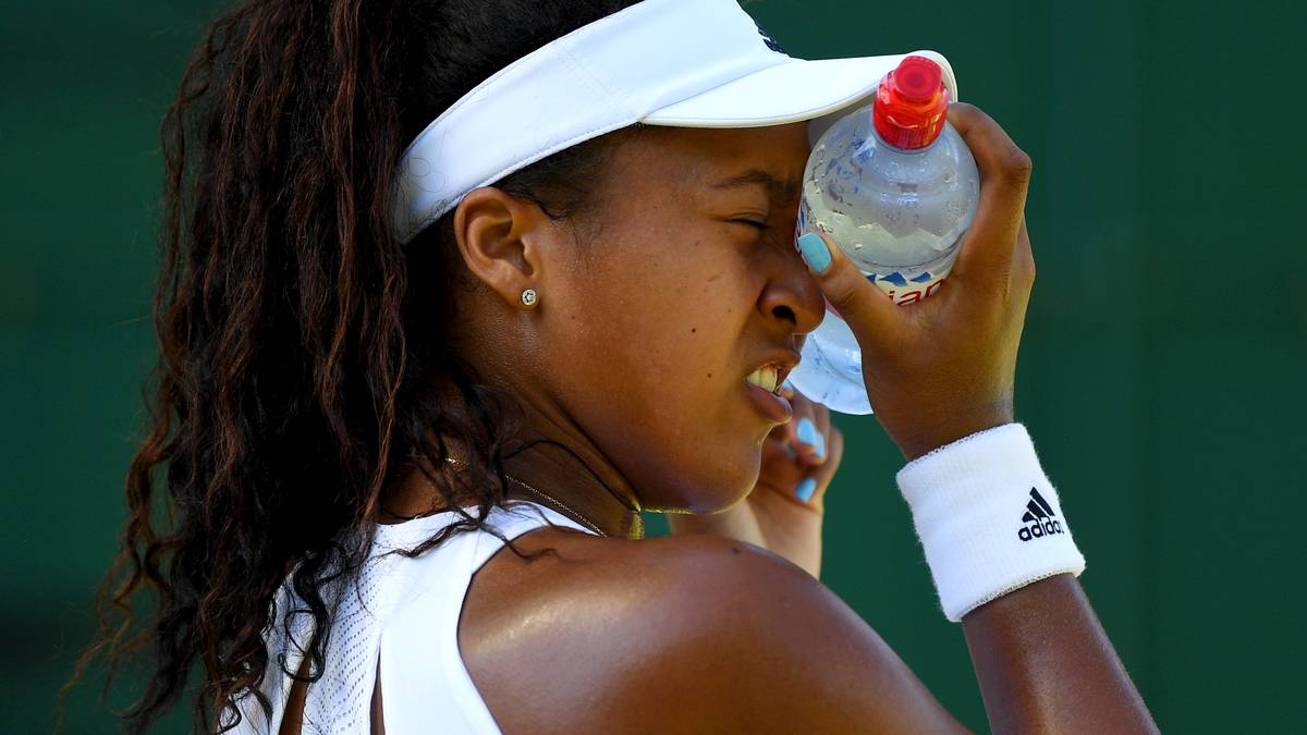 Naomi Osaka kühlt sich mit einer eiskalten Wasserflasche in den Pausen ab