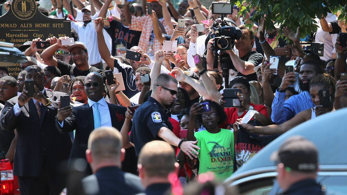 Als der Leichenwagen vorbeifährt, werden zahlreiche Kameras gezückt