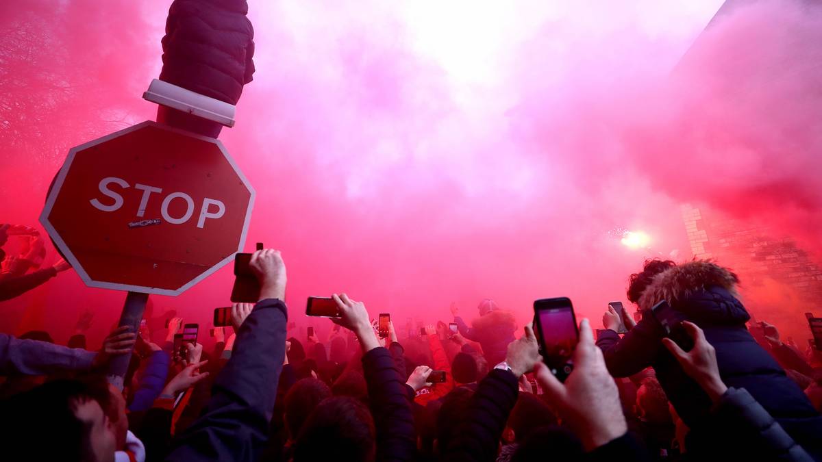 Während der rote Nebel durch die Luft wabert, wird der Bus auch mit Flaschen, Dosen und anderen Gegenständen beworfen