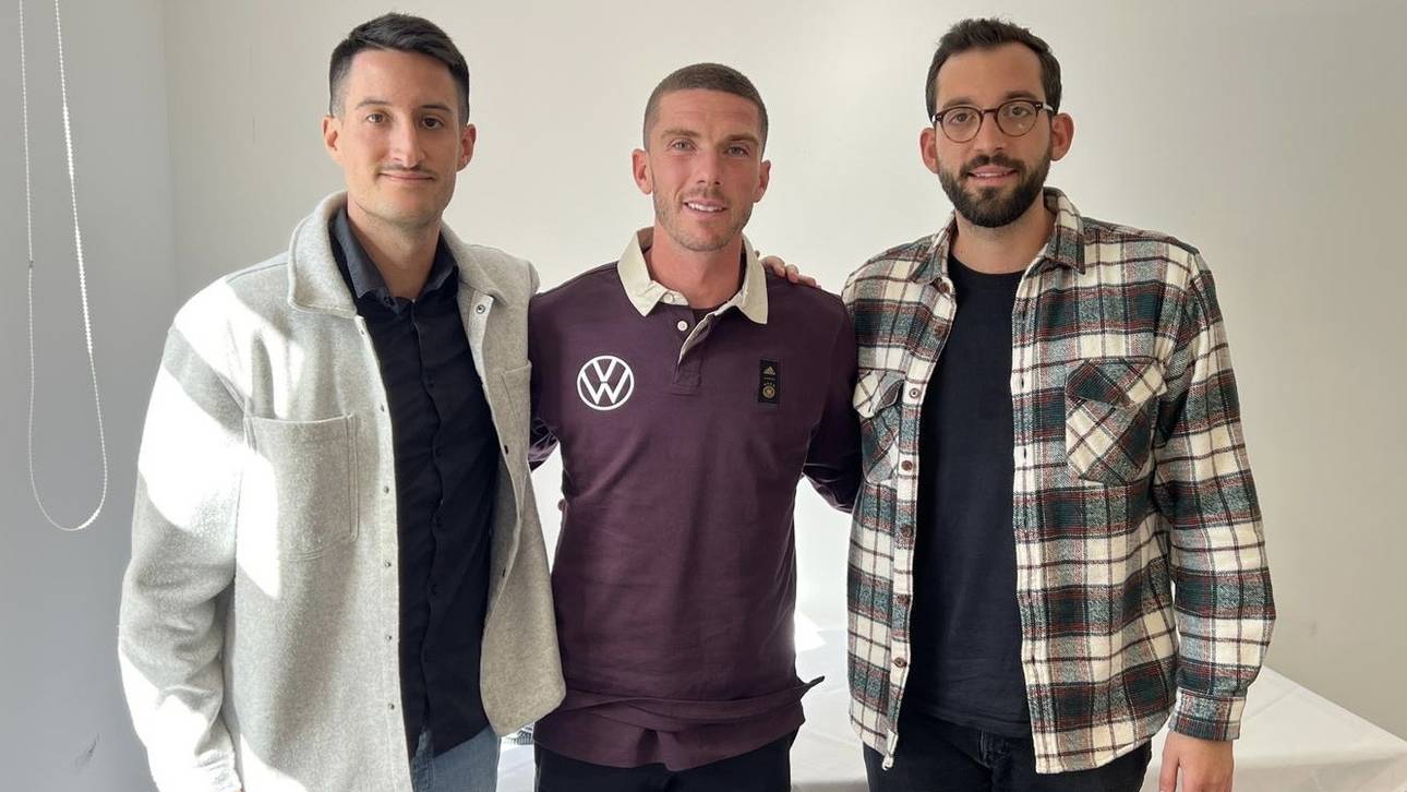 Die SPORT1-Chefreporter Kerry Hau (l.) und Patrick Berger (r.) trafen Robin Gosens (M.) im Teamquartier der Nationalmannschaft zum Interview