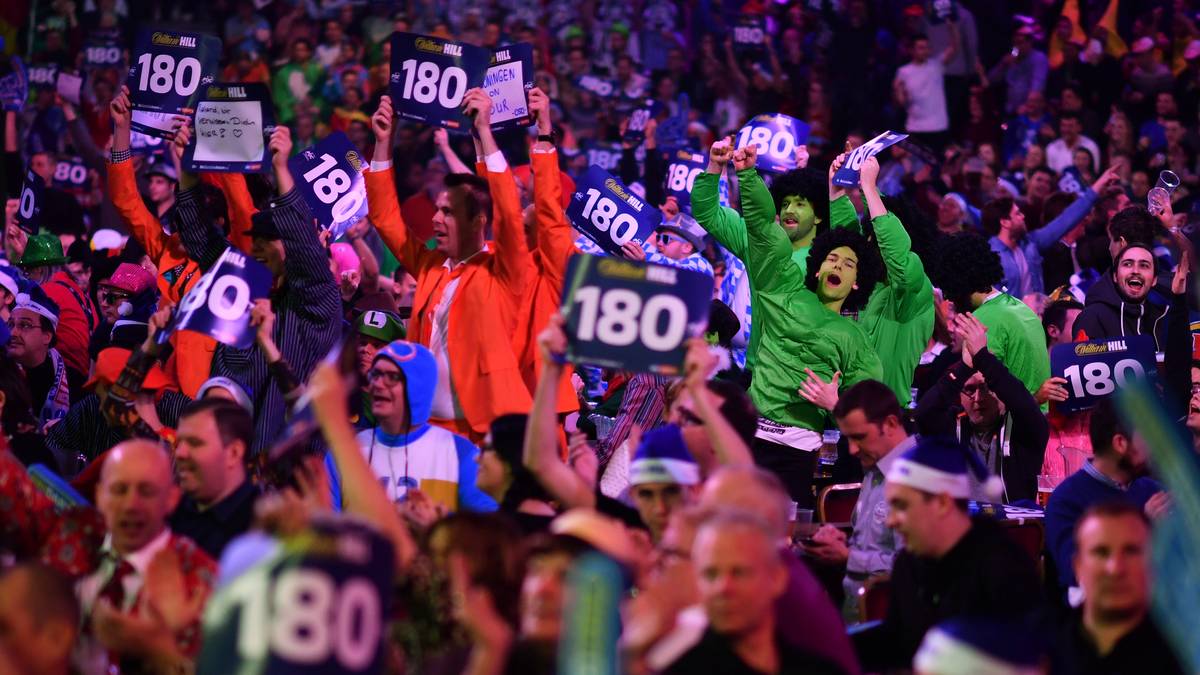 Darts ohne Fans ist kaum vorstellbar. Jedes Mal, wenn ein Spieler alle drei Pfeile in der Triple-20 versenkt, werden die "180"-Schilder ausgepackt und wild geschwenkt. Bei der WM wurden zuletzt 80.000 solcher Pappschilder verteilt. Auch 180er gibt es immer mehr. Im vergangenen Jahr gelang den Profis dies 880 Mal
